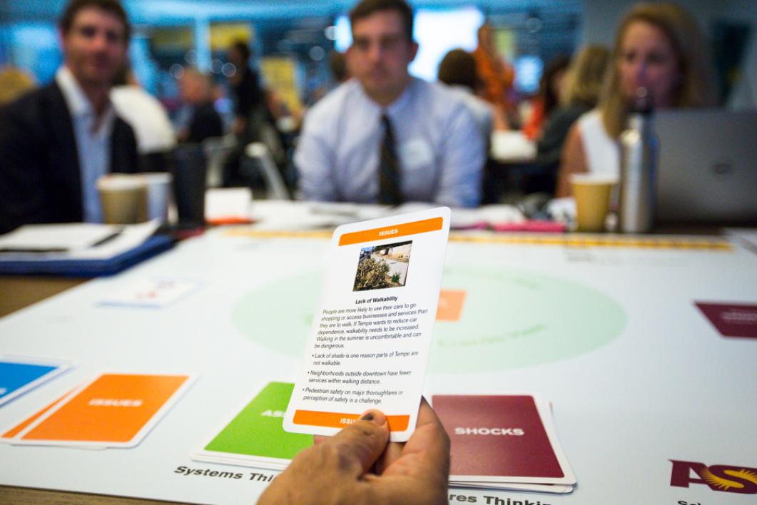 person picking up brochure card at table with people in professional clothes