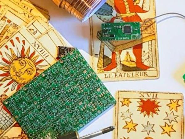 small green circuit board on top of tarot cards